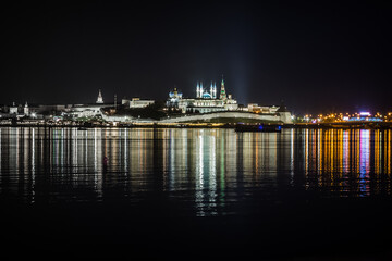 Fototapeta na wymiar The beautifully illuminated embankment is reflected in the Kazanka River in the city of Kazan on a clear warm summer night