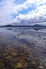 雲の広がる雄大な空の下の湖。日本の北海道の屈斜路湖。