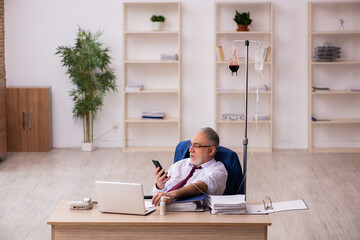 Old male employee in blood transfusion concept