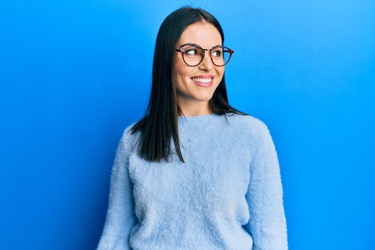 Young brunette woman wearing casual clothes and glasses looking to side, relax profile pose with natural face and confident smile.