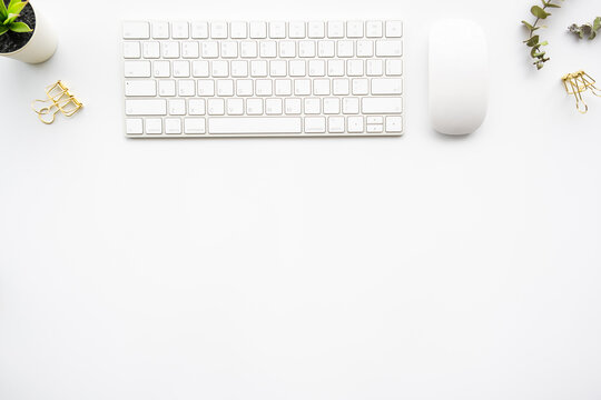 Beutiful white office desk table with computer keyboard and mouse with office supplies. Top view with copy space, flat lay.