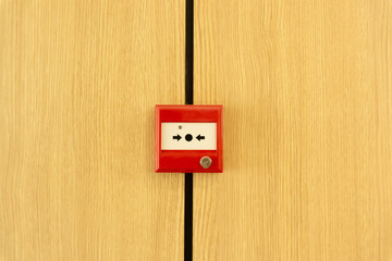 The red box of fire alarm sign on yellow wooden container