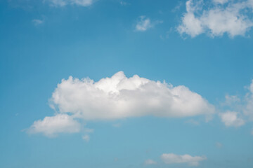 Naklejka na ściany i meble Upward view to cloudscape scene of white fluffy cloud on vivid blue sky