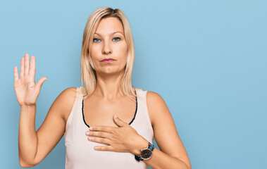 Middle age caucasian woman wearing casual clothes swearing with hand on chest and open palm, making...