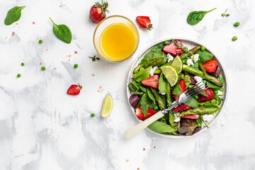 Healthy salad of fresh green asparagus, strawberry, rocket and cottage cheese salad. Diet banner, menu recipe place for text, top view