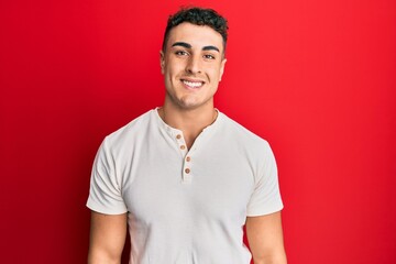 Hispanic young man wearing casual white t shirt with a happy and cool smile on face. lucky person.