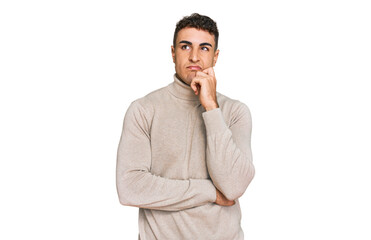 Fototapeta premium Hispanic young man wearing casual turtleneck sweater serious face thinking about question with hand on chin, thoughtful about confusing idea