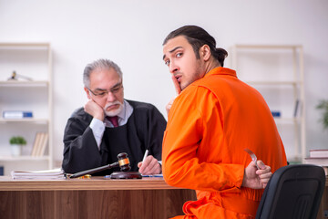Old male judge meeting with young captive in courthouse