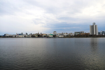 Fototapeta premium City on the background of water in the evening. View from the embankmen
