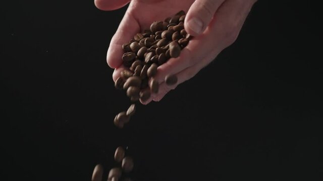 Slow motion mam pour coffee beans over balck background