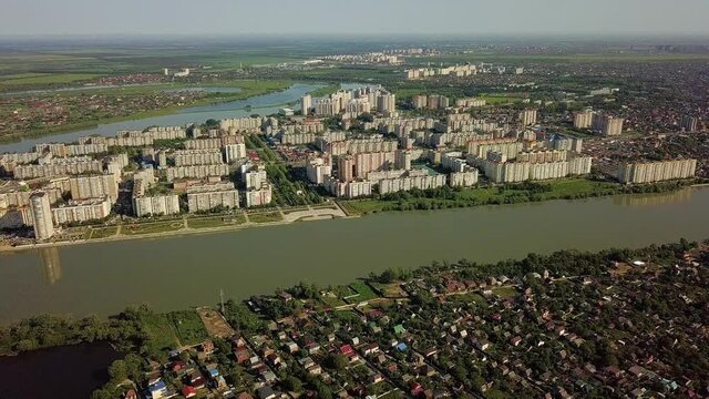 aerial panoramic top view of the multi-storey buildings of the microdistrict located on the bend of the Kuban River in Krasnodar on a spring sunny morning