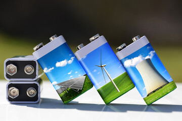 Battery with solar panels, wind turbines and nuclear power plant. Energy resources concept. 