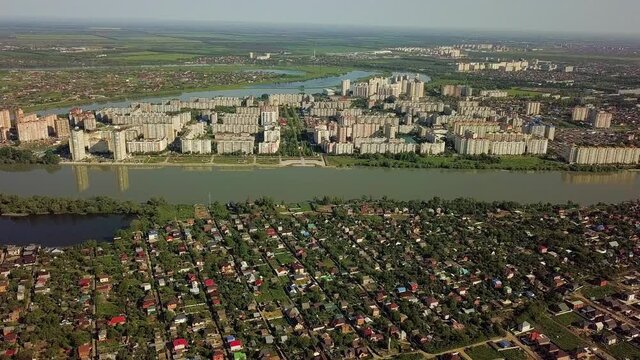 aerial panoramic top view of the multi-storey buildings of the microdistrict located on the bend of the Kuban River in Krasnodar on a spring sunny morning