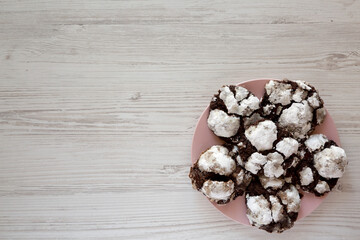 Homemade Chocolate Crinkle Cookies on a pink plate, top view. Flat lay, overhead, from above.