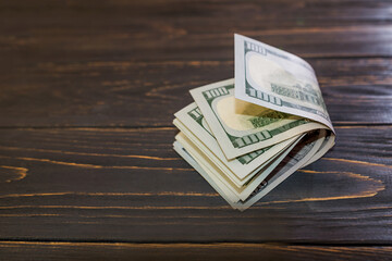 100 dollars banknotes on a wooden background.