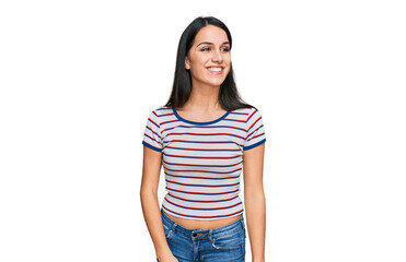 Obraz premium Young hispanic girl wearing casual striped t shirt looking away to side with smile on face, natural expression. laughing confident.