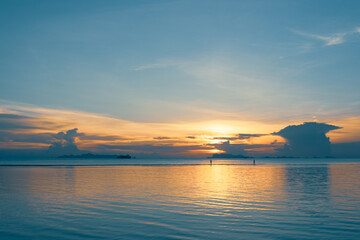 Silhouettes of people walking on the summer beach at sunset 