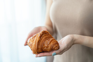 Woman hand serving baked crispy croissants.