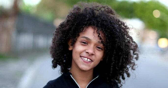 Black preteen girl smiling portrait. Brazilian mixed race child with curly hair face