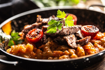 Tomato sauce gnocchi with sous-vide beef and fresh tomatoes served in a dark plate