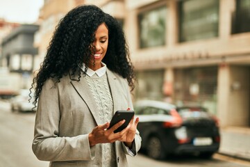 Middle age african american businesswoman using smartphone at the city.