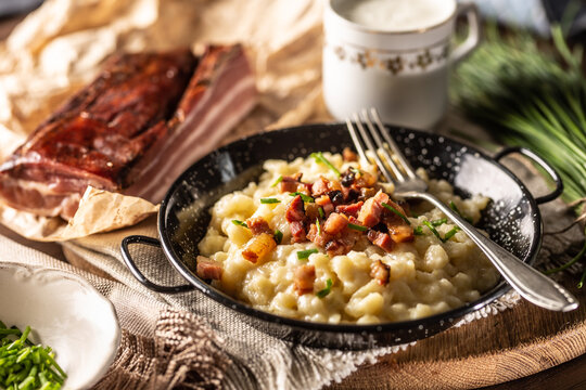 Slovak national dish bryndzove halushky served next to bacon and a gcup of milk
