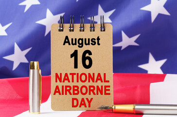 Against the background of the US flag lies cardboard with the inscription - NATIONAL AIRBORNE DAY