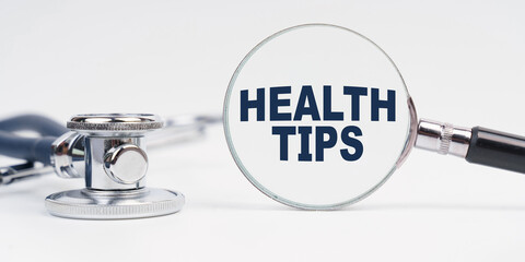 There is a stethoscope on the table, a magnifying glass with the inscription - Health Tips