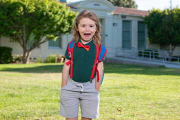 School, kids education concept. Child with rucksacks standing in the school park. Pupil with backpacks outdoors.