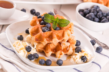 Waffles with blueberries and whipped cream.