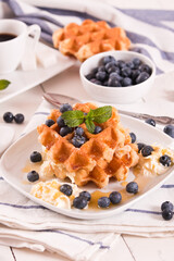 Waffles with blueberries and whipped cream.