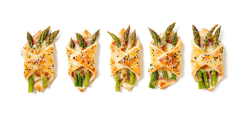 Baked green asparagus with ham and cheese in puff pastry sprinkled with sesame seeds and green...
