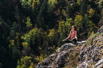 Attractive woman doing yoga. Healthy lifestyle. Woman doing yoga in the mountains. Girl doing yoga...