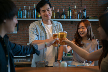 Group of Asian friend clinking a glass of beer and enjoy drinking beer at bar, alcohol, beer drinking, friend party, group of friend, casual meeting, bar and restaurant or friend and beer concept