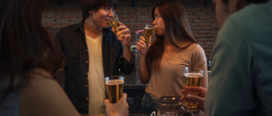 Banner photo of group of Asian friend clinking a glass of beer and enjoy drinking beer at bar, alcohol, beer drinking, friend party, casual meeting, bar and restaurant or friend and beer concept