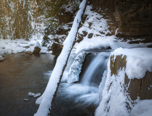 Winter mountain waterfall. Snowy mountain landscape with a waterfall. Carpathian mountains in Ukraine