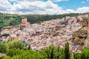 Fototapeta na wymiar View of Spanish white town with castle and bell tower. Alcala del Jucar, Castilla La Mancha, Spain.
