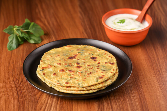 Palak paratha spinach paratha , parantha , chapati Indian flatbread roti made from spinach served with a yogurt mint dip and mango pickle, North Indian breakfast food Delhi India.