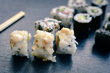 Japanese sushi food. Maki ands rolls with tuna, salmon, shrimp.Assorted sushi. Rainbow roll, uramaki, hosomaki and nigiri.  Sushi Set sashimi  served on stone slate