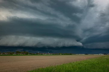 Fotobehang Upcoming shelf cloud of a strong thunderstorm over the Dutch plains © Menyhert