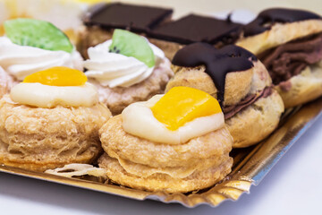 Assortment of mini cakes with cream, chocolate and assorted fruits