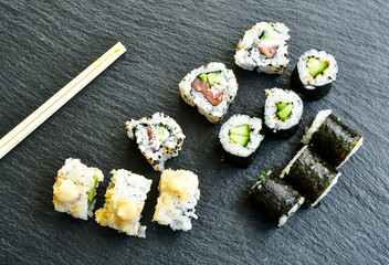 Japanese sushi food. Maki ands rolls with tuna, salmon, shrimp.Assorted sushi. Rainbow roll, uramaki, hosomaki and nigiri.  Sushi Set sashimi  served on stone slate