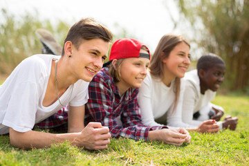 Fototapeta premium multinational modern teens lie in the park on the grass