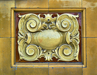Detail of elaborate and decorative ceramic tiles in yellow gold and warm brown