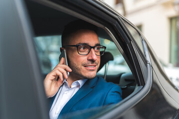 Businessman in the Back Seat of a Taxi Having Phone Call.