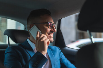 Businessman in the Back Seat of a Taxi Having Phone Call.