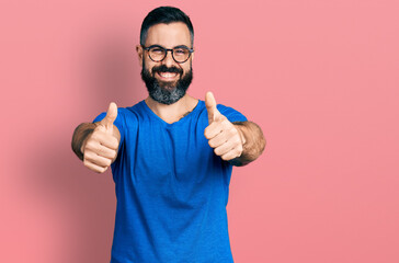 Hispanic man with beard wearing casual t shirt and glasses approving doing positive gesture with...