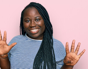 Young black woman with braids wearing casual clothes showing and pointing up with fingers number...