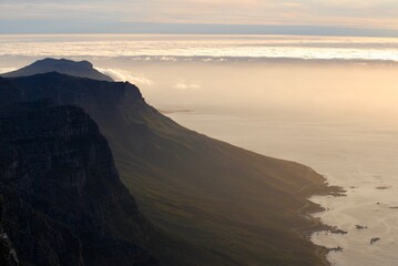 View of the twelve apostles from Table Mountain in Cape Town at sunset, with a cloudy sky 