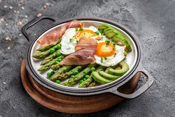 fresh organic asparagus with prosciutto, avocado and fried eggs. Healthy food, ketogenic diet, diet lunch concept. Keto Paleo diet menu, top view